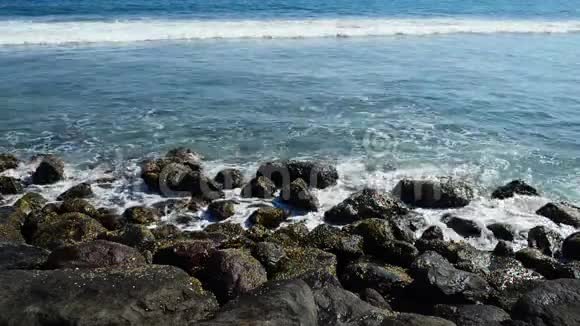一股巨浪击中岩石波浪撞击热带海滩上的岩石形成飞溅的形状在岩石上的强大波浪视频的预览图