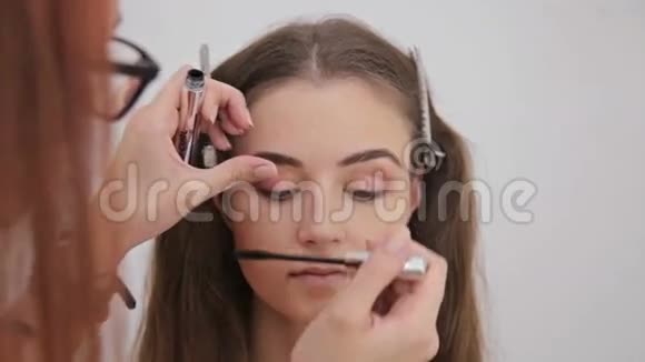 近距离射击专业化妆师在模特睫毛上涂睫毛膏视频的预览图