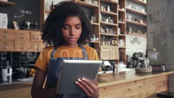 一位非洲女咖啡馆老板用数码平板电脑视频的预览图