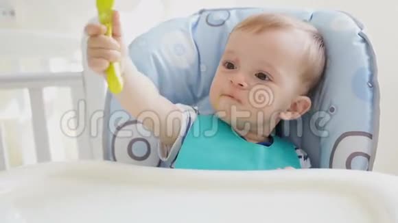 可爱的小男孩一边吃粥一边玩勺子视频的预览图