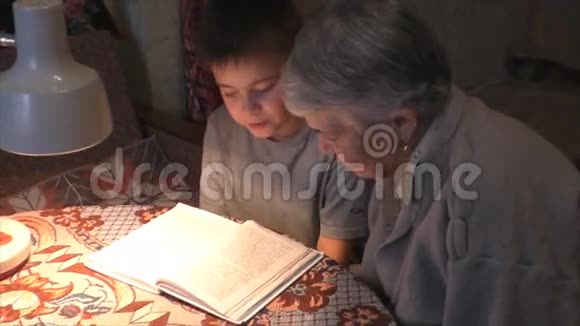 前祖母和曾孙一起在桌旁看书视频的预览图