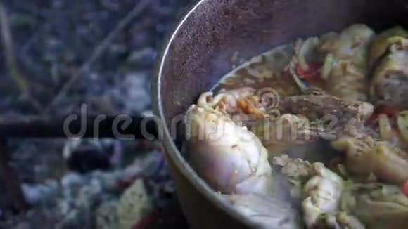 在一个金属大锅里的明火上煮饭视频的预览图