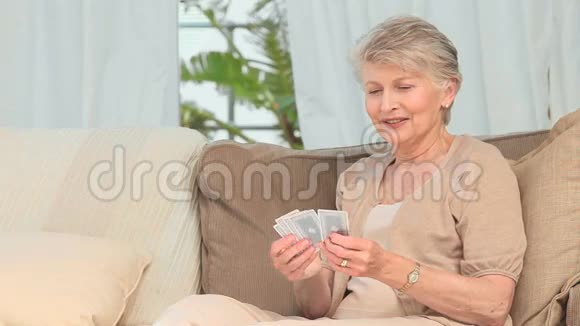 一位手里拿着卡片的老妇人视频的预览图
