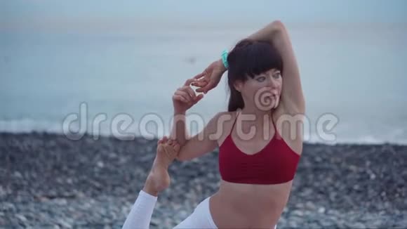 女人独自在海滩上做瑜伽视频的预览图