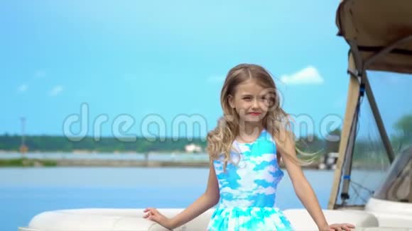 可爱的小女孩在码头的水面上摆姿势拍照视频的预览图