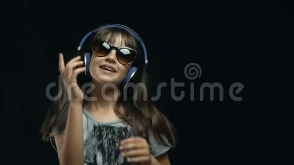 年轻可爱的女孩用耳机跳舞视频的预览图