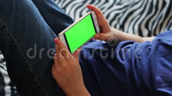 手持触摸屏设备用智能手机特写男孩的手彩色钥匙绿色屏幕视频的预览图