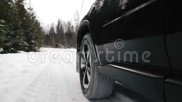 汽车在一条雪林路上行驶视频的预览图