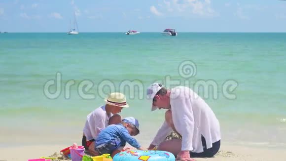快乐的家庭孩子们在沙滩上玩玩具热带岛屿天气炎热视频的预览图