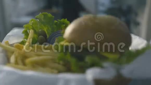 汉堡包掉在盘子上薯条放在盘子里视频的预览图