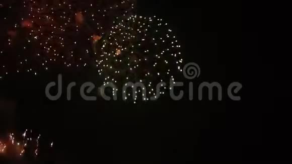 巨大的烟花在夜空上形成在漆黑的夜晚背景下五颜六色的雨洒着烟花节日活动视频的预览图