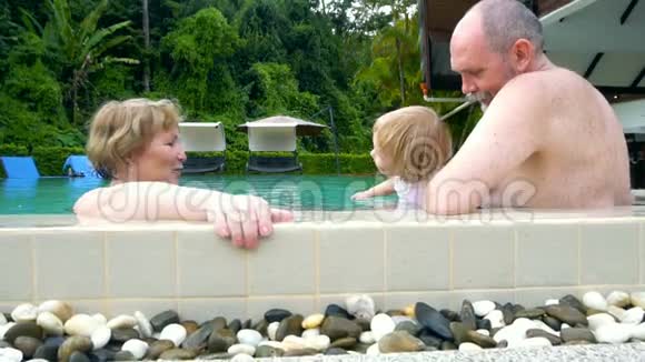 祖父母和女婴在游泳池玩耍视频的预览图