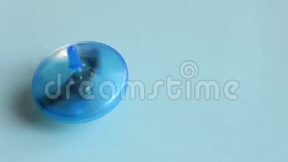 在蓝色桌子上旋转的塑料陀螺视频的预览图
