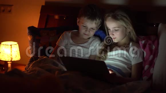 孩子们在床上玩平板电脑视频的预览图