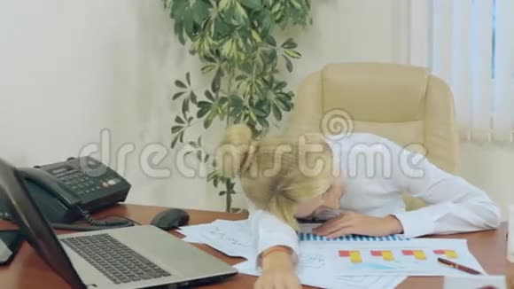 金发女郎在桌子上睡着了报纸也在里面视频的预览图