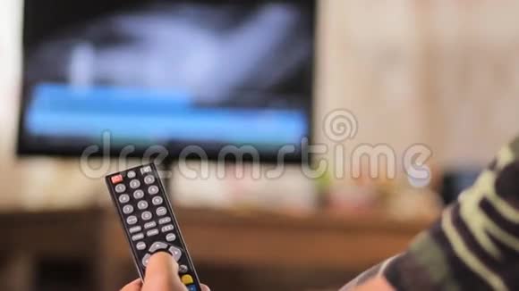 老人坐在一张皮椅上在家里更换频道电视遥控器快关门视频的预览图