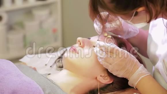 美容师用特殊的刷子用眉毛画客户视频的预览图