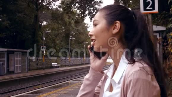 女商人在火车站台上用电话视频的预览图