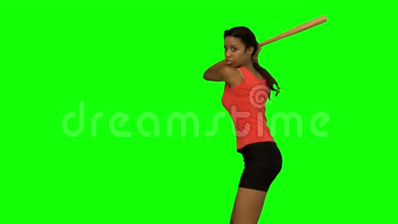 在绿色屏幕上打棒球的漂亮女人视频的预览图