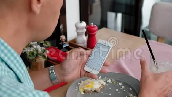 一个成熟的男人在咖啡馆里用烤面包和鸡蛋吃早餐视频的预览图