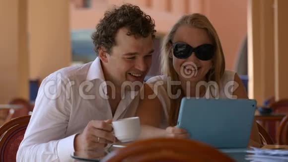 男人和女人在平板电脑上看照片视频的预览图
