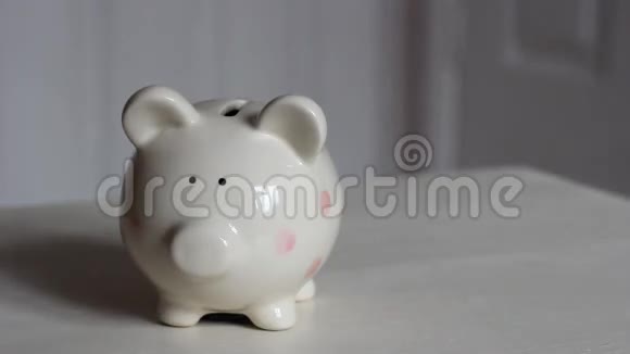 女孩在猪银行放欧元硬币视频的预览图