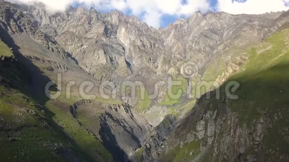 从无人驾驶飞机到格鲁吉亚卡兹贝吉山附近有峡谷和裂缝的山脉的空中景观视频的预览图