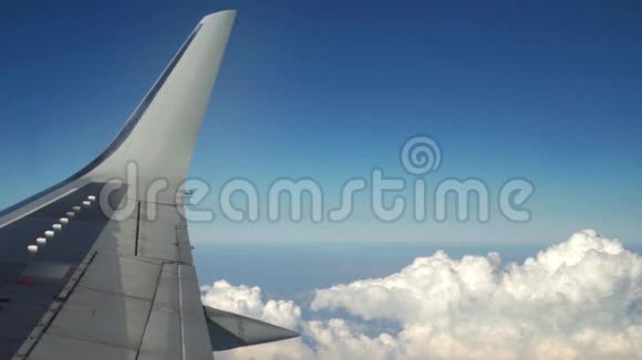 飞机正通过白云在蓝天上飞行从窗户看到飞机机翼旅行和视频的预览图