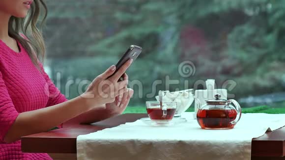 女人在咖啡馆里用手机喝茶视频的预览图