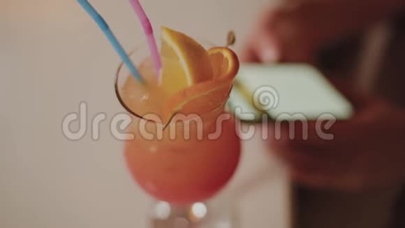 美丽的女孩与一个美丽的新鲜明亮的晚上鸡尾酒在咖啡馆视频的预览图