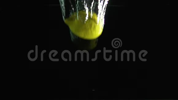 柠檬落入水中在黑色背景下拍摄视频的预览图