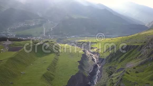 从无人驾驶飞机到格鲁吉亚卡兹贝吉山附近有峡谷和裂缝的山脉的空中景观视频的预览图