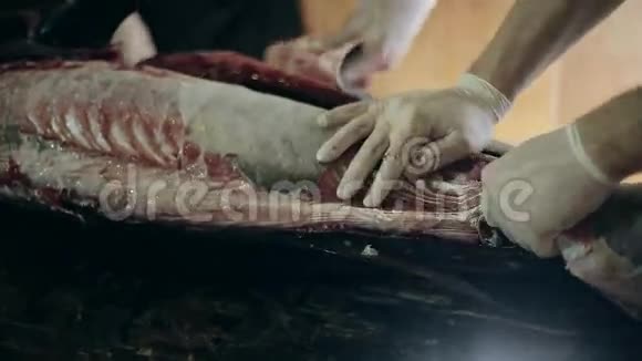 鱼的生产人员脱掉一身大剑鱼的衣服从皮肤上清洁做成鱼片视频的预览图