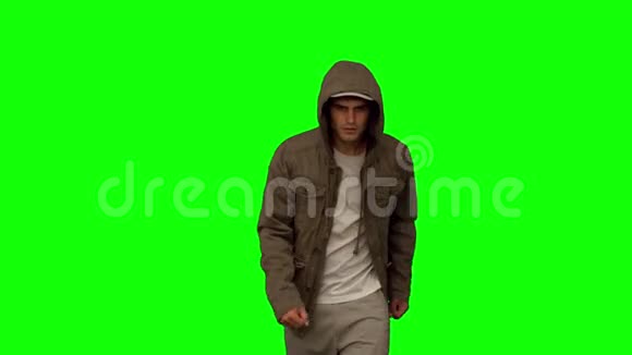 穿着外套的人在绿色屏幕上朝镜头走去视频的预览图