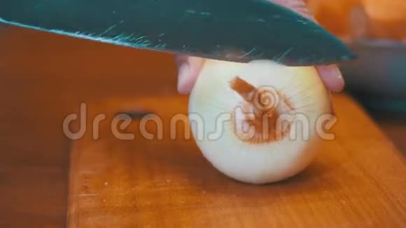 女人手在厨房板上用刀切洋葱视频的预览图