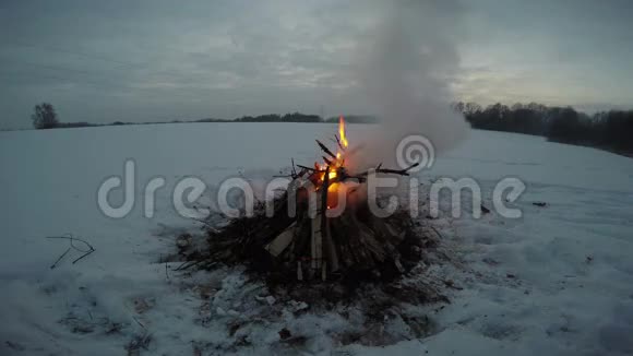 深雪中熊熊燃烧着篝火的景观视频的预览图