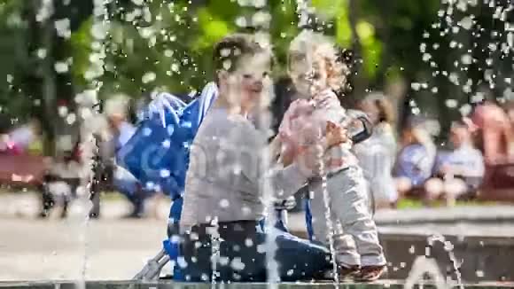 幸福的母亲和婴儿在喷泉附近视频的预览图