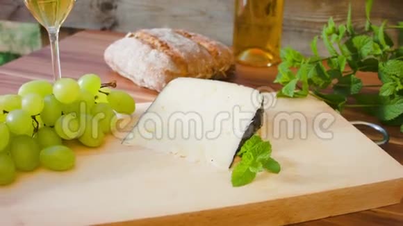 一块硬奶酪放在木板上上面有葡萄视频的预览图