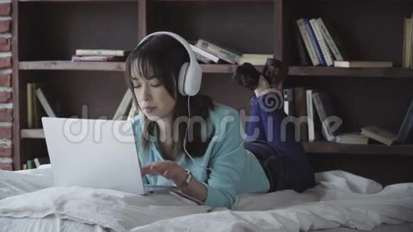 戴着耳机的女人用笔记本电脑工作视频的预览图