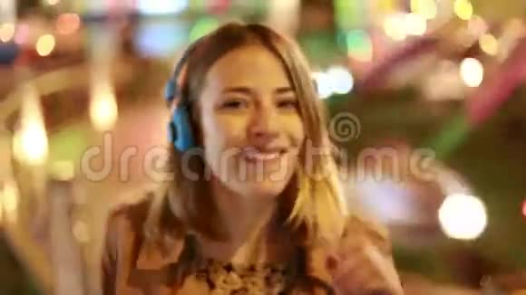 金发女孩用耳机随着音乐的节奏摇头视频的预览图