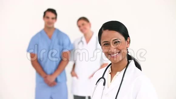 医生微笑着她的同事们在她身后视频的预览图