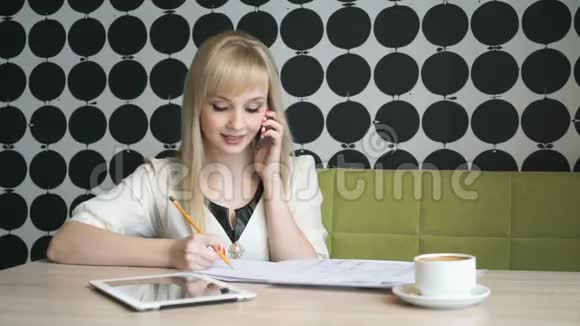 女孩子在咖啡休息时用手机说话视频的预览图