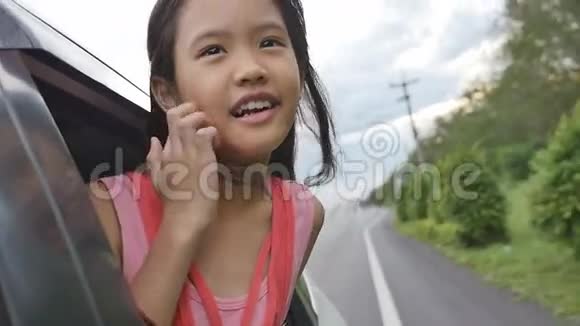 小女孩在车窗上玩耍家庭在农村旅行视频的预览图