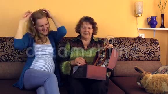 带着奶奶的孕妇把项链挂在古石上视频的预览图