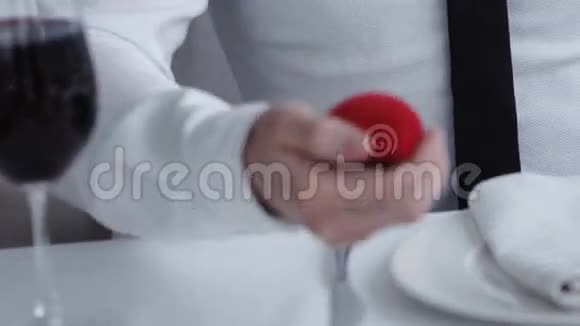 把男人手里拿着一个盒子带着戒指向他的女朋友求婚餐馆视频的预览图