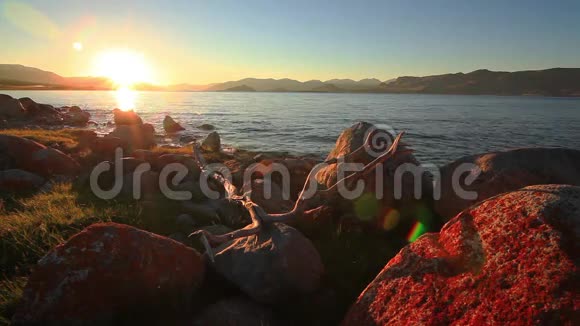 在山湖的岩石海岸上日落蒙古霍顿湖视频的预览图