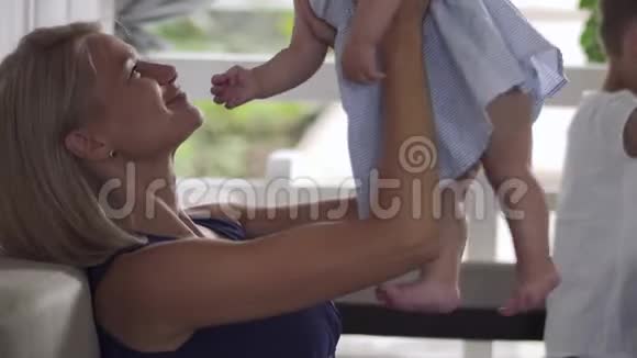 年轻的母亲吻她的宝贝女儿视频的预览图