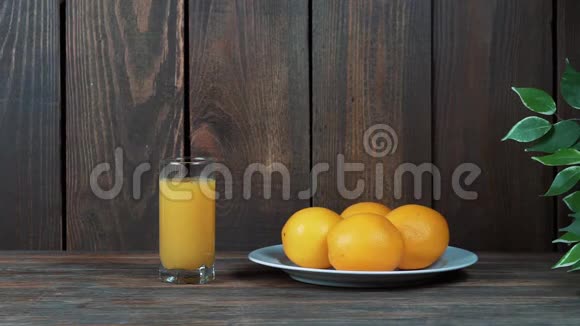 一杯鲜榨橙汁倒挤橙汁在木制背景上视频的预览图