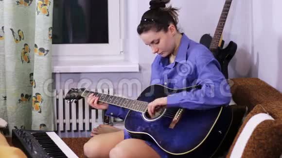 年轻漂亮的女孩学弹吉他视频的预览图