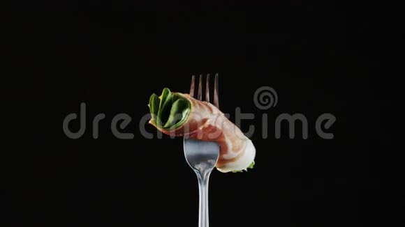 黑色背景带火腿和生菜的叉子视频的预览图